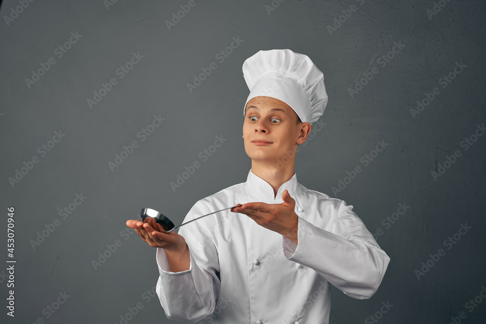 a man in a chef's uniform with a ladle in his hands cooking food kitchen professional a man in a chef's uniform with a ladle in his hands cooking food kitchen professional