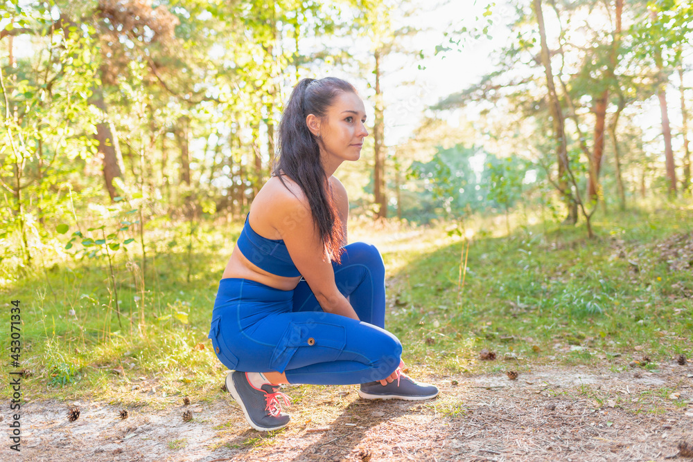 Young beautiful attractive sport runner woman tying her shoe sneaker smiling happy ready for running and jogging summer Young beautiful attractive sport runner woman tying her shoe sneaker smiling happy ready for running and jogging summer