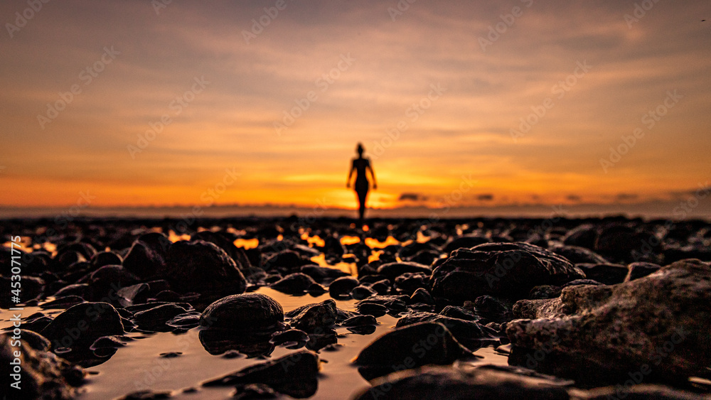 femme flou et de dos pendant un coucher de soleil en bord de met avec  jolies couleurs sur l'ile de la Réunion Photos | Adobe Stock