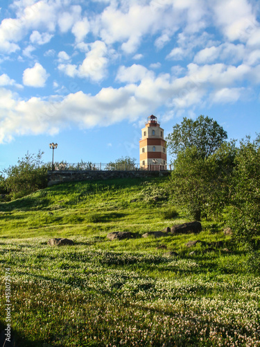 Murmansk lighthouse view from below, enclosed by a fence and a beautiful sky from above. Cityscape of Murmansk - a city in the north of Russia.