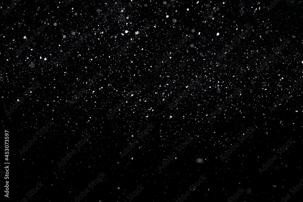 Best photo of real falling medium sized snowflakes out of focus on black background for overlay blending mode.