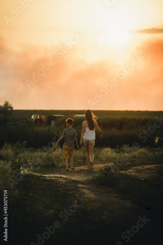 children walk along the path at sunset