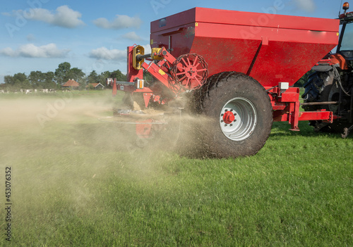 Fertilizer spreader. Fertilizer. Tractor. Farming. Meadow. Grass. Chalk. Netherlands