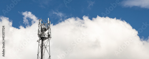 Bottom perspective pov of modern metal steel mobile 5g network wireless telecom tower against clear blue sky background on bright day. Microwave signal broadband equipment base line station mast