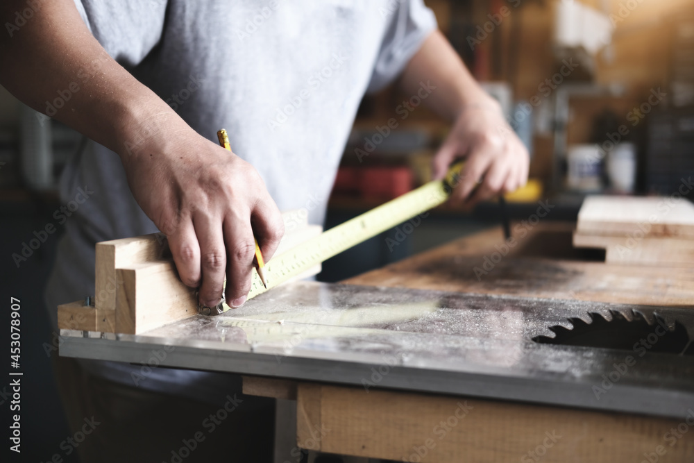 do-it-yourself concept Craftsmen use a tape measure to assemble wooden pieces to make wooden tables for customers. do-it-yourself concept Craftsmen use a tape measure to assemble wooden pieces to make wooden tables for customers.