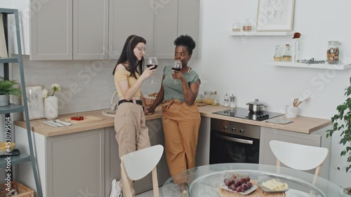 Wallpaper Mural Slowmo shot of multi-ethnic queer couple standing in cozy kitchen and chatting while drinking red wine Torontodigital.ca