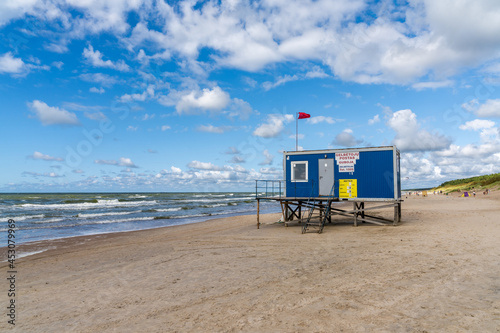 beautiful white sand beach on the Baltic Sea coast of Lithuania with a lifeguard hut on the foreground photo