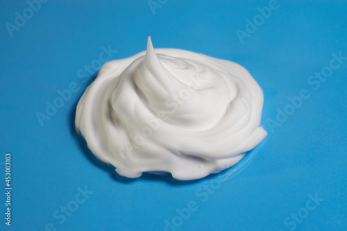 White shaving foam on a blue background