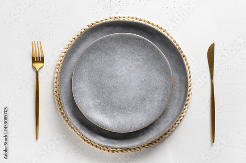 Elegance table setting with empty gray plate with golden cutlery as mockup on white. Top view. photo