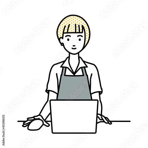 デスクで座ってPCを使っているカフェ店員の女性