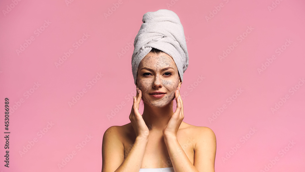 smiling woman with terry towel on head applying scrub on face isolated on pink smiling woman with terry towel on head applying scrub on face isolated on pink