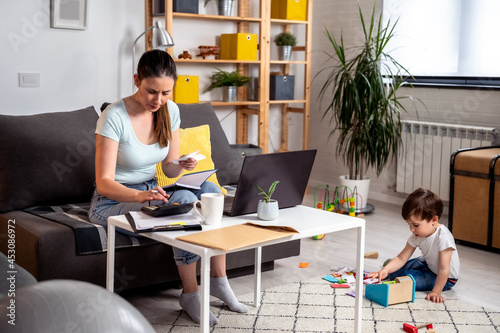 Photography Young woman single mother is doing home budgeting and calculating mortgage