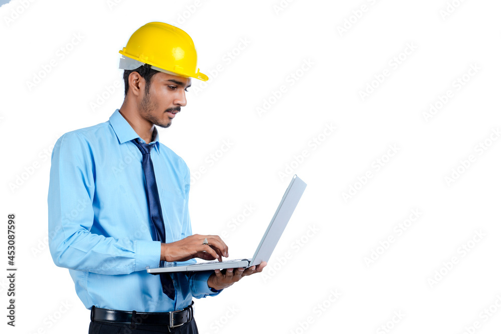 young Indian engineer in uniform and using laptop on white background. young Indian engineer in uniform and using laptop on white background.