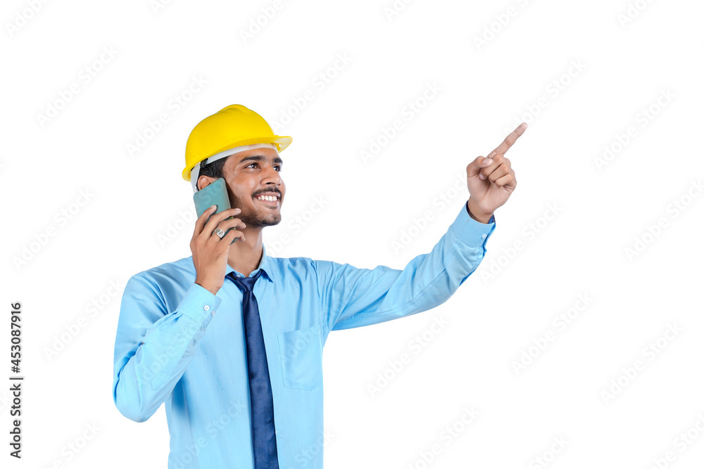 Young indian engineer or construction site worker using smartphone. Young indian engineer or construction site worker using smartphone.