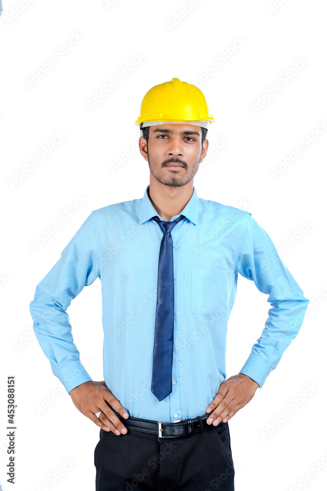 Young Indian male engineer wearing yellow color hard hat on white background. Young Indian male engineer wearing yellow color hard hat on white background.
