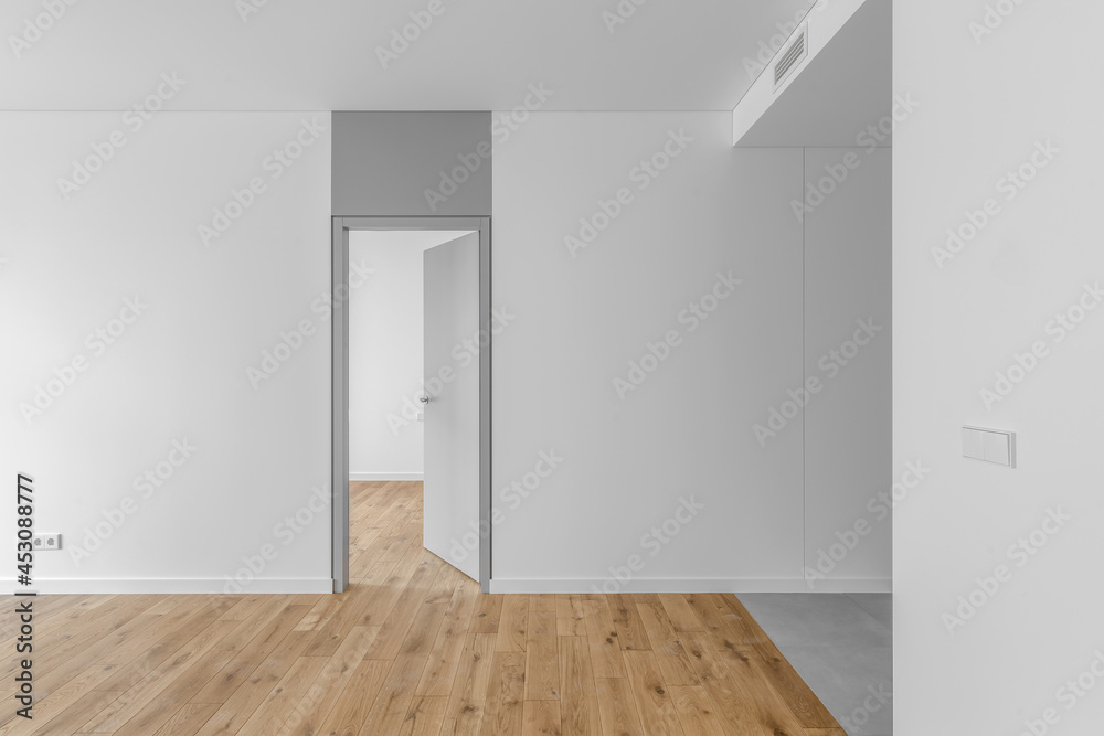 Empty minimalist modern room with white walls, opened grey door, grey floor tiles and oak wood floor Empty minimalist modern room with white walls, opened grey door, grey floor tiles and oak wood floor