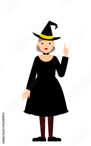 ハロウィンの仮装、魔女姿の女の子が指さしをするポーズ