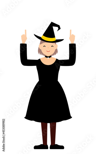 ハロウィンの仮装、魔女姿の女の子が両手で指さしをするポーズ