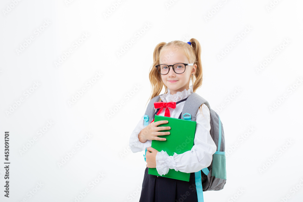 a little schoolgirl girl in a school uniform holds a book isolated on a white background a little schoolgirl girl in a school uniform holds a book isolated on a white background