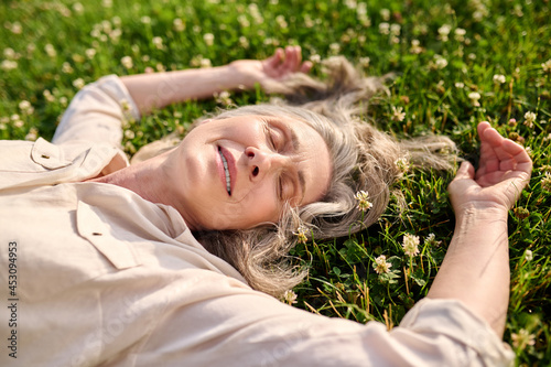 Woman with drooping eyelids lying on grass photo