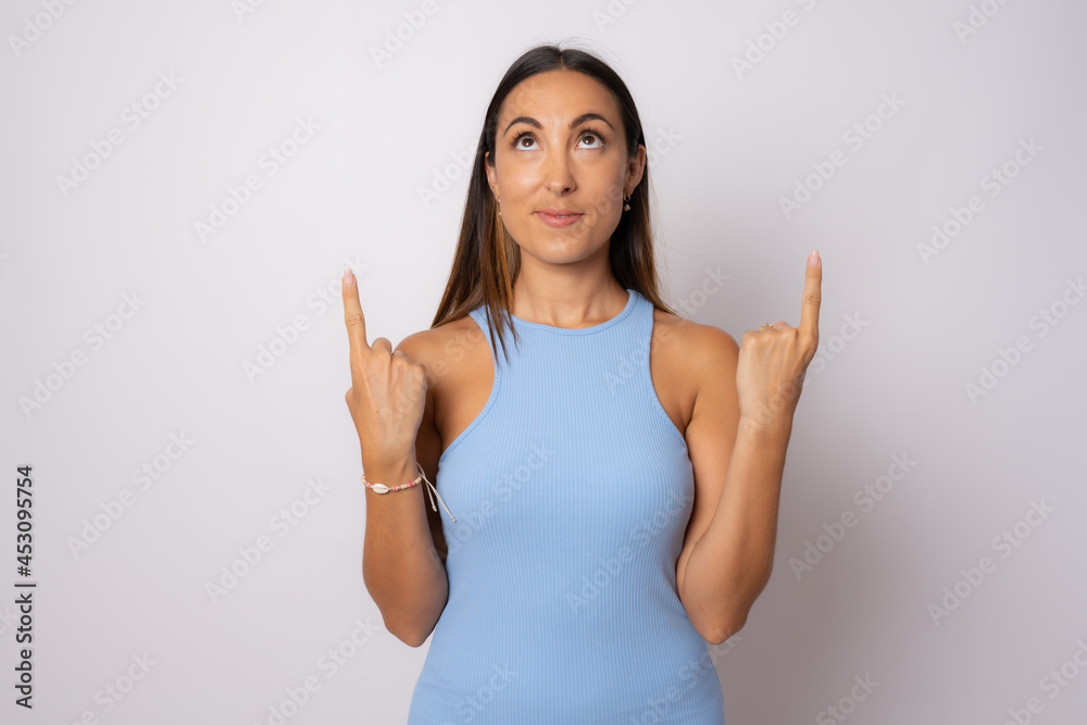 Portrait of beautiful young woman pointing up over white background. Portrait of beautiful young woman pointing up over white background.