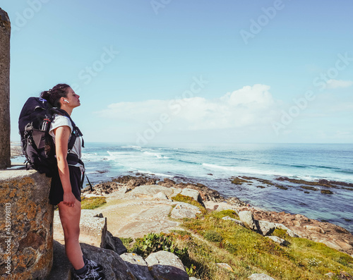 pilgrim woman in a high viewpoint against beach and sea photo