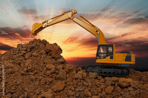 Yellow Excavators are digging the soil in the construction site on the sunlight sky background