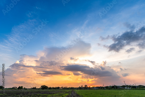 Twilight blue bright and orange yellow dramatic sunset sky in countryside or beach colorful cloudscape texture with white clouds air background.