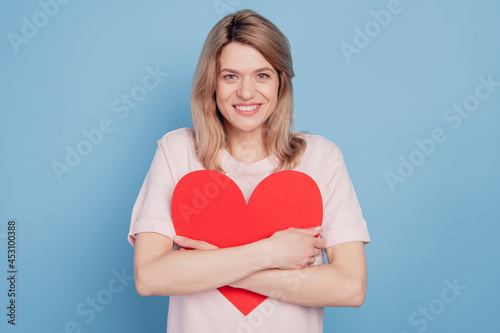 Portrait of dreamy inspired girl embrace red heart postcard love herself concept on blue background