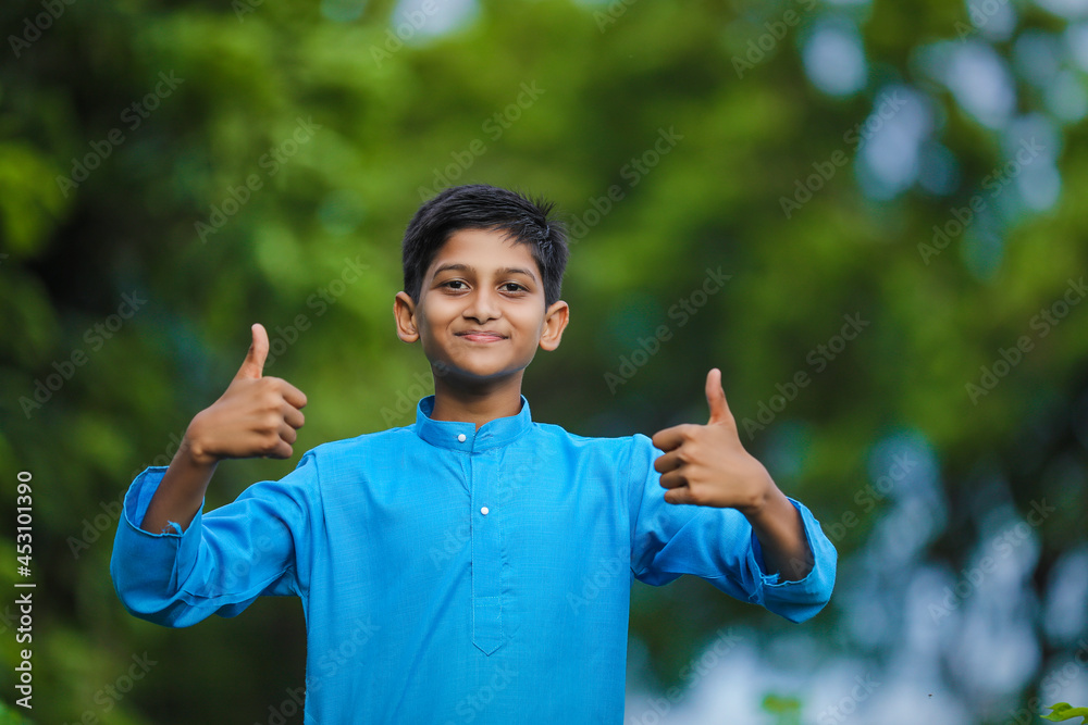 Cute indian little child in traditional wear and standing at agriculture field Cute indian little child in traditional wear and standing at agriculture field