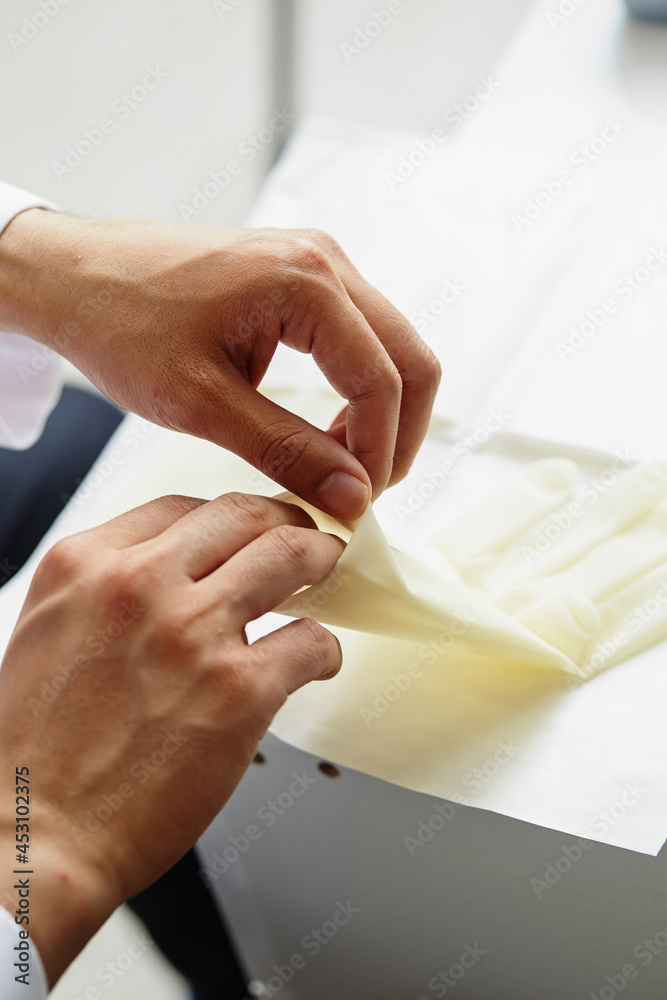 Close-up of a doctor's hand wearing surgical gloves Close-up of a doctor's hand wearing surgical gloves