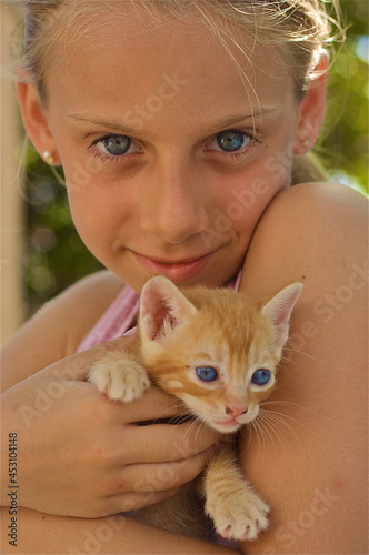 A little Blonde girl with orange kitten