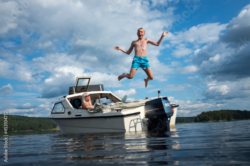 Boy jumping into lake photo