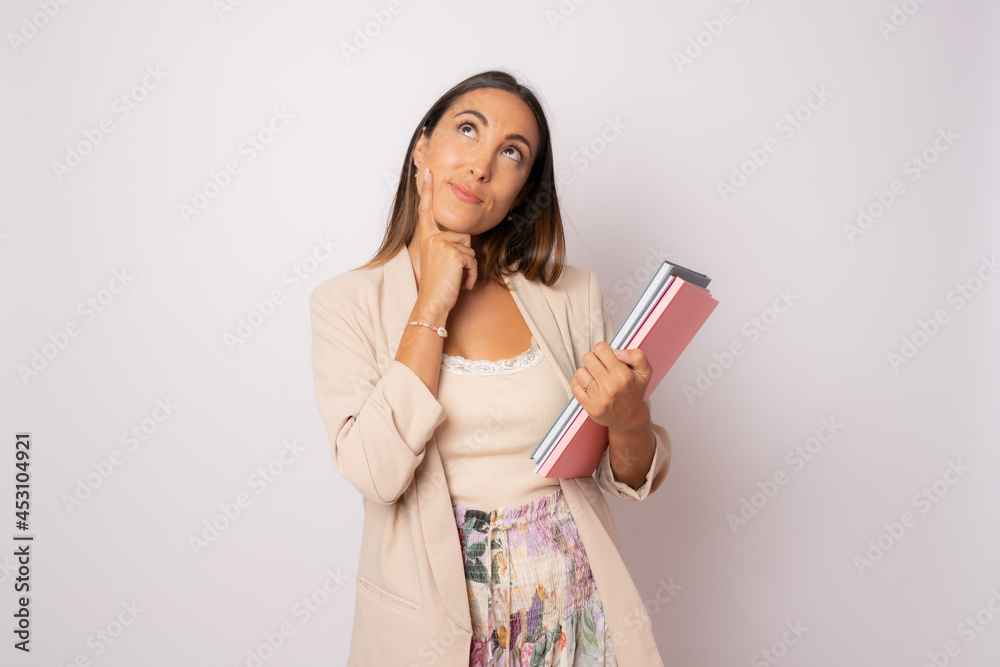 Pensive young woman holding books. isolated portrait of school teacher. Pensive young woman holding books. isolated portrait of school teacher.