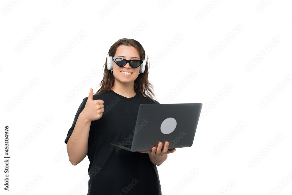 Young smiling woman is showing the thumb up while holding the laptop. Young smiling woman is showing the thumb up while holding the laptop.