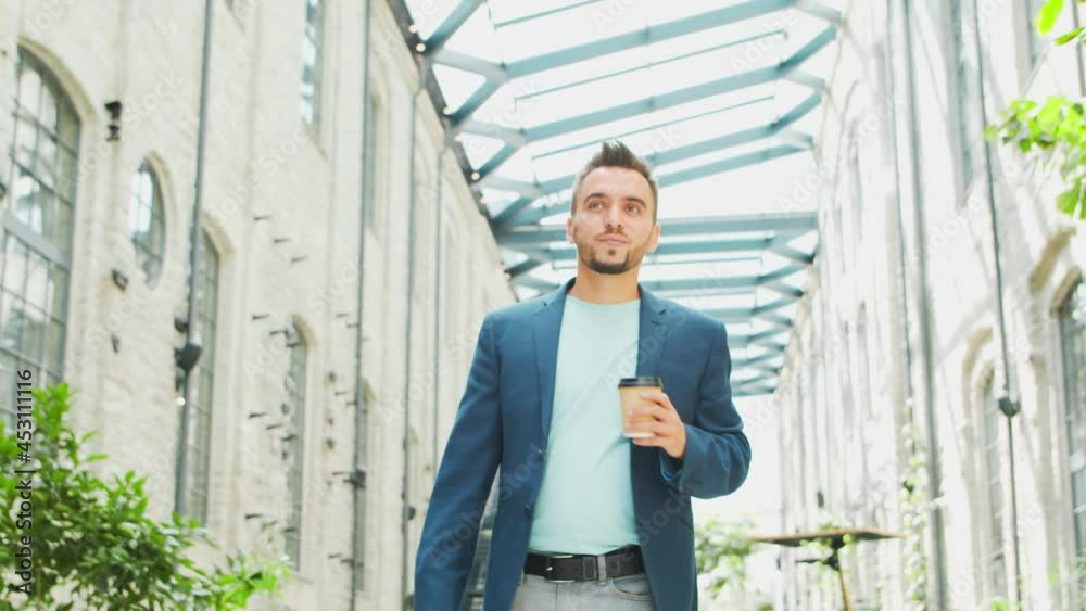 A young successful businessman is walking down the street. Man in a casual wear. Business, freelance and remote work. A young successful businessman is walking down the street. Man in a casual wear. Business, freelance and remote work.