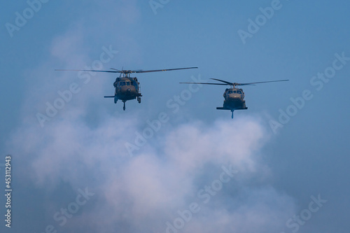 American Black Hawk helicopter Sikorsky UH - 60M attack takes off at the operation with weapons between smoke in battle war