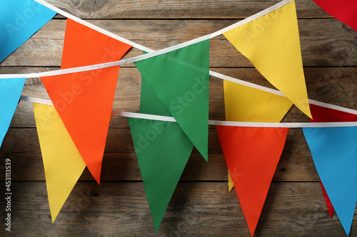 Valokuva Colorful bunting party flags hanging on wooden wall