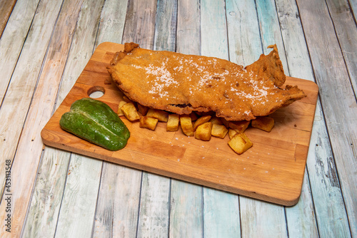 Great cachopo of beef, ham and cheese breaded with roasted potatoes and fried peppers photo