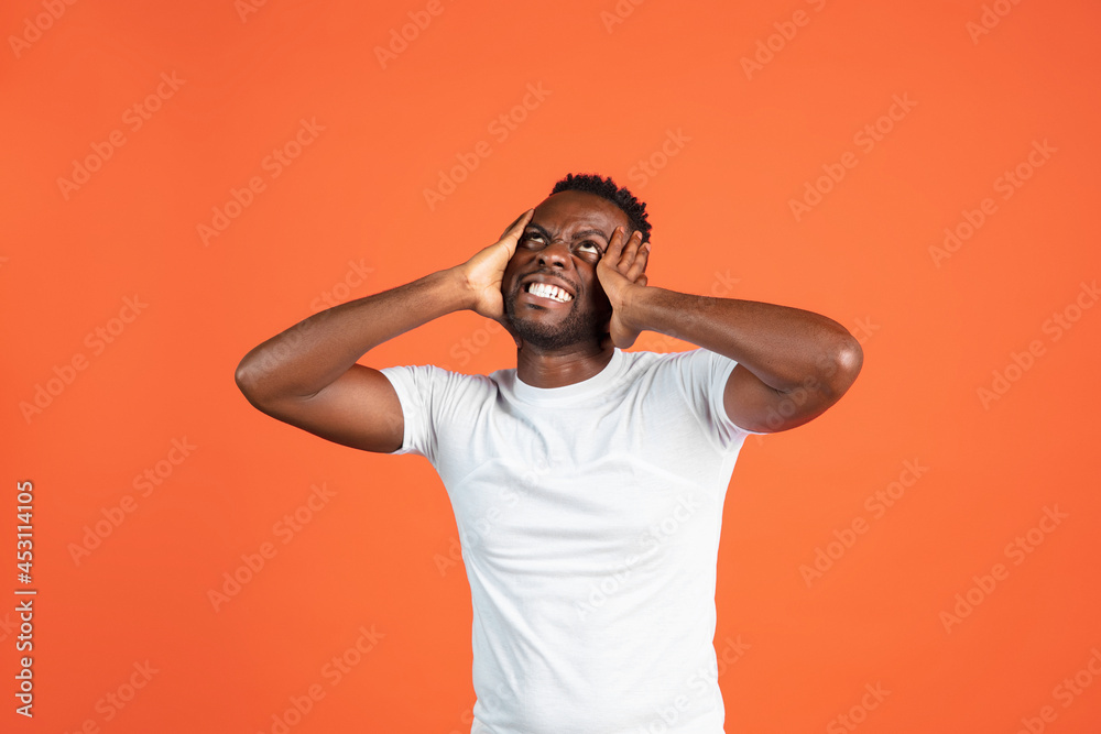 Portrait of African young man in casual clothes isolated on red color studio background. Concept of human emotions, facial expression, youth, feelings, ad. Portrait of African young man in casual clothes isolated on red color studio background. Concept of human emotions, facial expression, youth, feelings, ad.