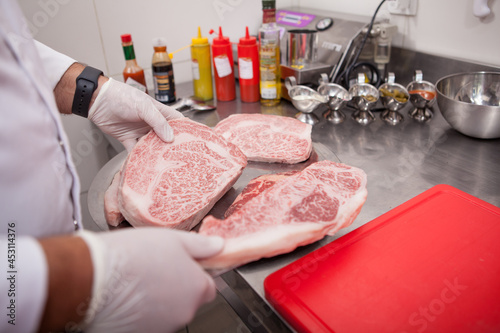 Cropped shot of a chef working on his kitchen, preparing marbled beef meat for steaks