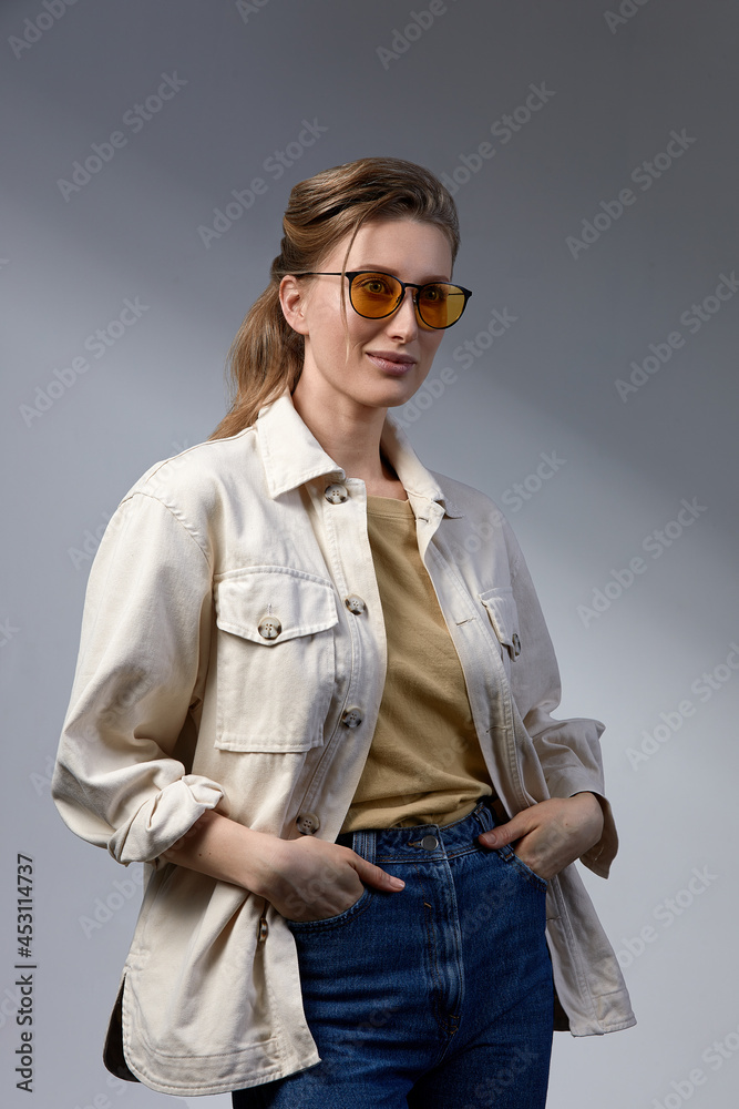 Confident young business woman 35-45 years old, blonde in stylish formal clothes and glasses, gray background, close-up. Business and career success concept. Confident young business woman 35-45 years old, blonde in stylish formal clothes and glasses, gray background, close-up. Business and career success concept.