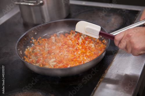 Chef frying vegetable mix on the pan