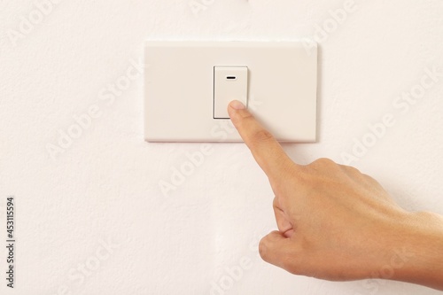 woman using index finger to turn off the light