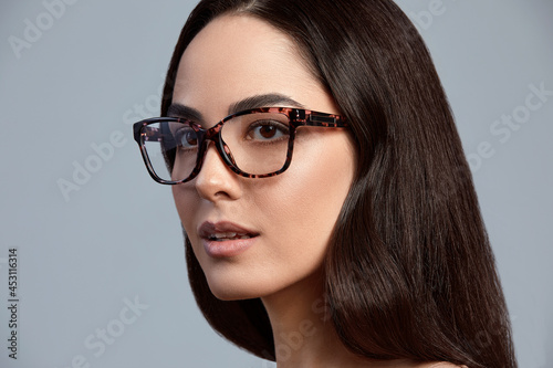 Confident young business woman 35-45 years old, blonde in stylish formal clothes and glasses, gray background, close-up. Business and career success concept.
