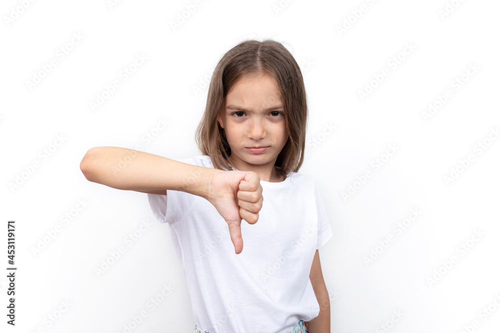 Unhappy little girl showing thumb down gesture. Unhappy little girl showing thumb down gesture.