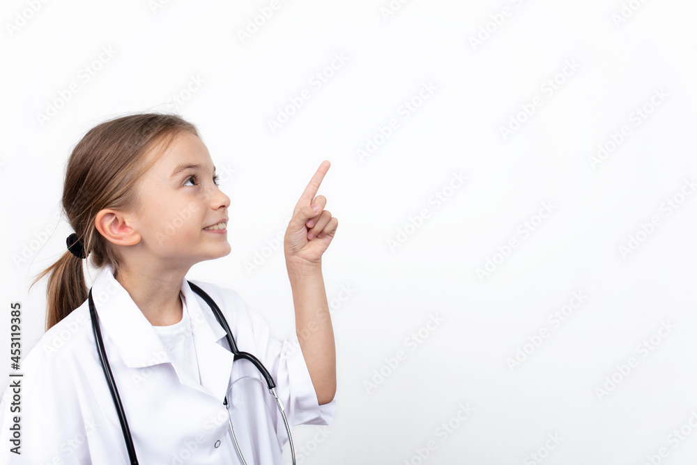 Smiling happy child girl in doctor's coat pointing at white background
Smiling happy child girl in doctor's coat pointing at white background