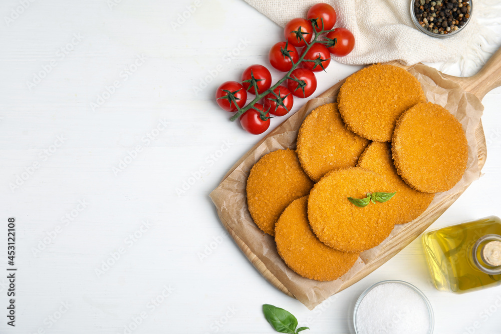 Delicious fried breaded cutlets served on white table, flat lay. Space for text Delicious fried breaded cutlets served on white table, flat lay. Space for text