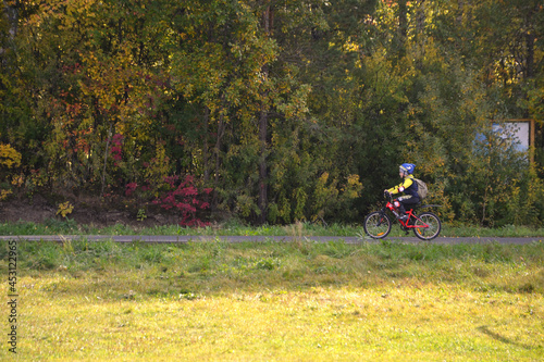 Boy riding a bike in the park in early autumn