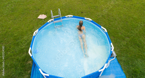 Obraz na plátně A shapely slim blonde in the garden pool. Photo from the drone